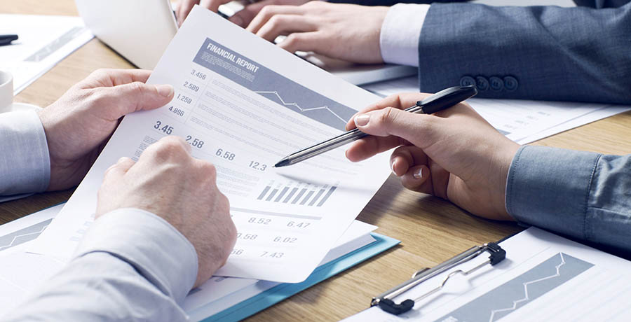 Professional financial service Business professionals working together at office desk, hands close up pointing out financial data on a report